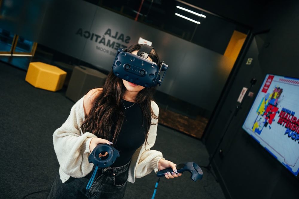 Pesquisadora com óculos e controles de realidade virtual